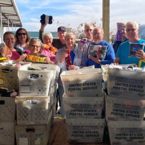 Men and women posing in front of dozens of bins full of socks